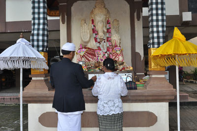 Rear view of people praying at idol ganpati