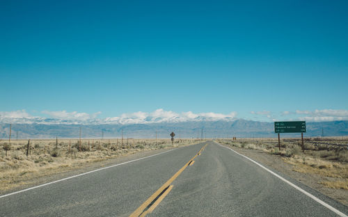 Road against clear blue sky