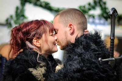 Couple wearing costume kissing while standing outdoors