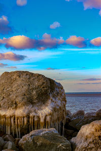 Scenic view of rocks on beach against sky