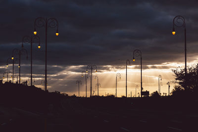 Cars on road against sky at sunset