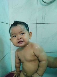 Portrait of cute baby boy in bathroom