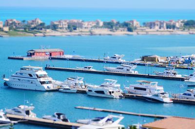 Boats moored in sea against blue sky