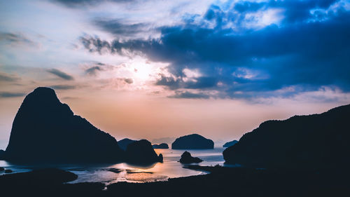 Scenic view of rocks in sea against sky during sunset