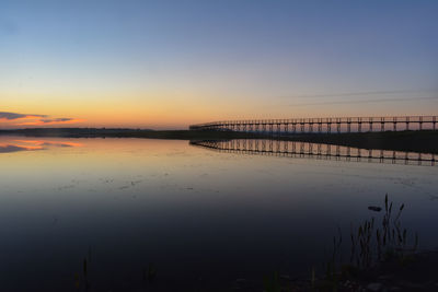 Scenic view of lake against orange sky