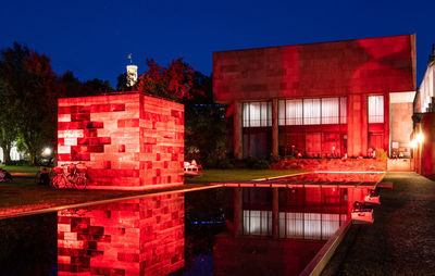 Red building by lake at night
