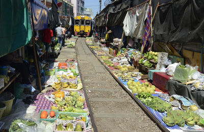 Train on railroad track amidst market stalls