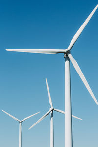 Close up of wind turbines against the blue sky