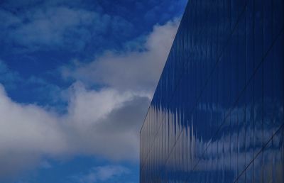 Low angle view of modern building against blue sky