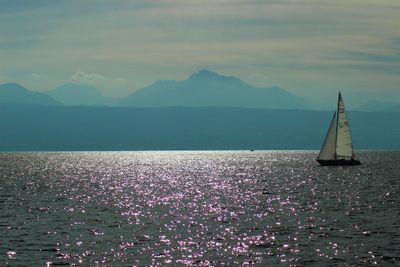 Scenic view of sea by mountains against sky