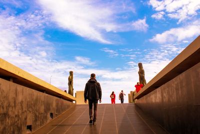 Rear view of people walking on footpath