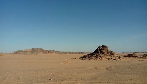 Sand dunes in desert against clear blue sky