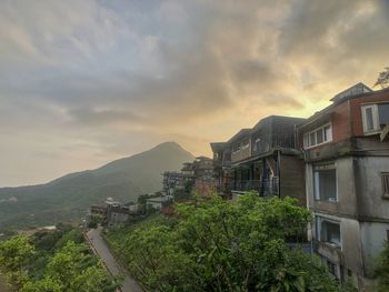 Panoramic view of buildings and mountains against sky during sunset