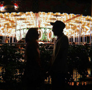 Side view of silhouette people at amusement park