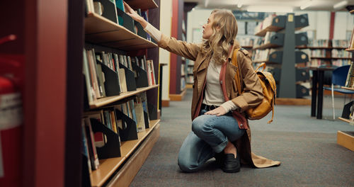 Rear view of woman standing in library