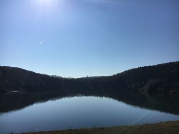 Scenic view of lake against clear blue sky