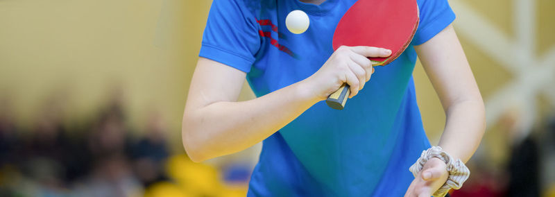 Midsection of player holding table tennis racket