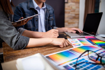 Midsection of woman using smart phone on table