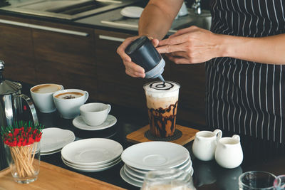 Midsection of coffee cup on table at cafe