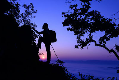 Silhouette man photographing against sky at night