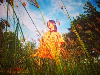 Low angle view of woman looking away while standing on field