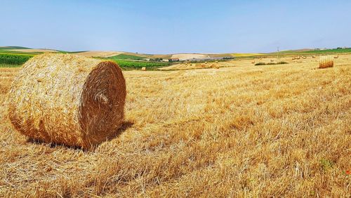 Hay bales on field against sky