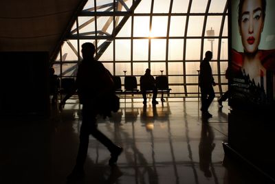 Silhouette people walking on railroad station platform