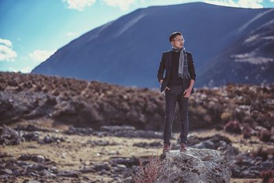 Full length of a man standing in desert against mountain against sky