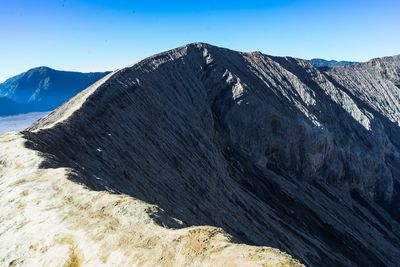 Scenic view of mountains against clear blue sky