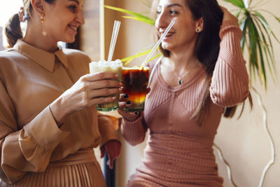 Portrait of smiling young woman drinking glass