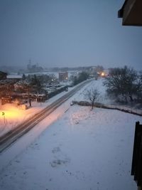 Snow covered road against clear sky at night