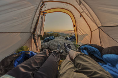 Low section of man relaxing on tent