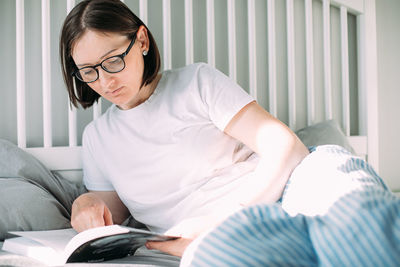 Young woman reading book at home