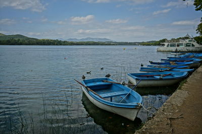 Boats moored in lake against sky