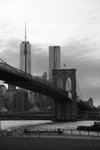 Brooklyn bridge over east river by one world trade center against sky