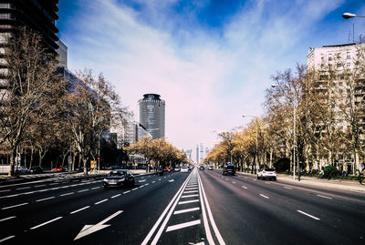 View of city street against cloudy sky