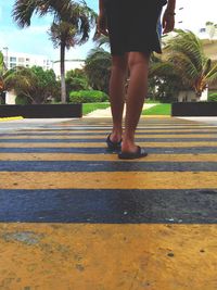 Low section of woman standing on road