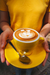 Midsection of woman holding coffee cup