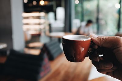 Midsection of man holding coffee cup