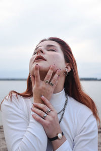 Portrait of beautiful woman against sea against sky