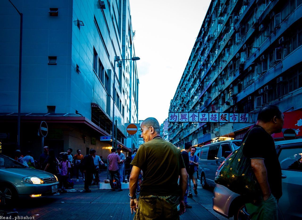PEOPLE ON STREET AGAINST BUILDINGS IN CITY