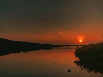 Scenic view of lake against orange sky