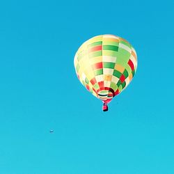 Low angle view of hot air balloon against clear blue sky