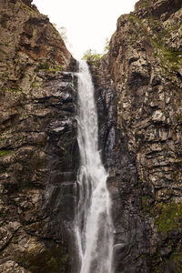 Low angle view of waterfall on rocks