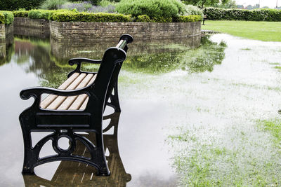 Empty bench on shallow water at park