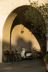 Passage in old town with bikes and scooter parked