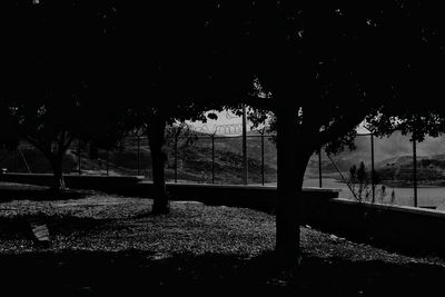 Silhouette trees in park against sky