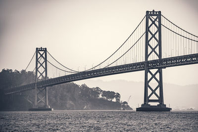 Bay bridge against clear sky at sunrise