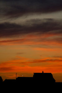 Silhouette buildings against orange sky