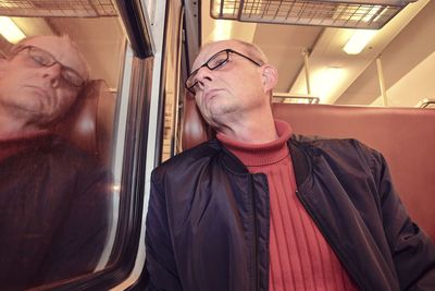 Middle age man looking out of the window of train. passenger during travel by high speed express